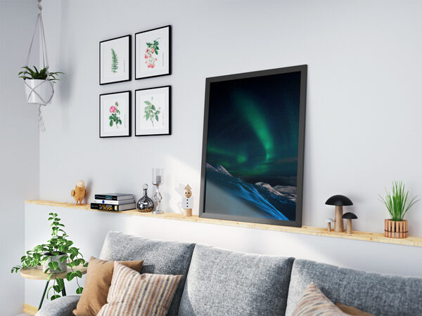 Karla kaplı dağları ve yıldızlarla dolu karanlık gökyüzünü aydınlatan canlı yeşil Kuzey Işıklarının uzun pozlama ile çekilmiş fotoğrafı.